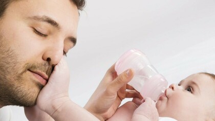 Un padre dando el biberón a su bebé