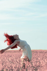 Ragazza si lascia cullare dal vento in un prato di fiori: ricordate sempre di essere la vostra causa e non l’effetto di quel che capita intorno a voi