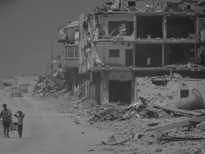 Families walk past the rubble of Gaza City as relentless bombings leave the urban landscape in ruins
