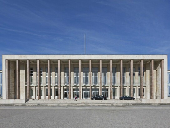 A fachada monumental da Faculdade de Letras de Lisboa ergue-se como templo moderno da cultura e da memória ocidental. Entre colunas, painéis e simetrias, a arquitectura converte-se em linguagem simbólica do conhecimento