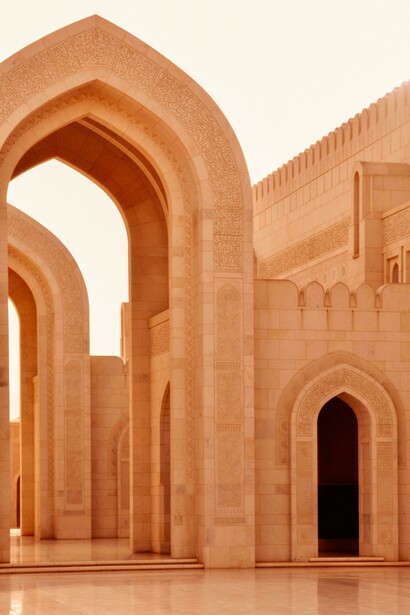 In Muscat, within the Muscat Governorate of Oman, the elegant arches of the Sultan Qaboos Grand Mosque stand as a stunning example of Islamic architecture