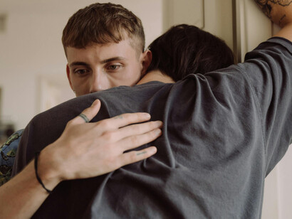 A man consoling another one, deeply moved