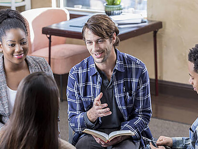 A self-assured middle-aged man engages enthusiastically in a Bible study session, contributing to the discussion with confidence