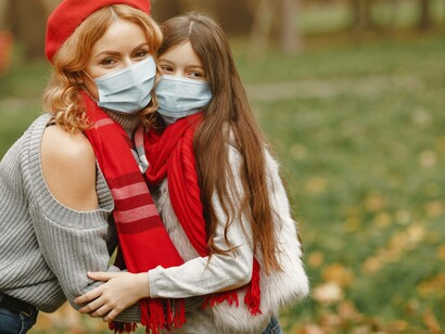 A mother and her daughter both wearing masks even in open spaces