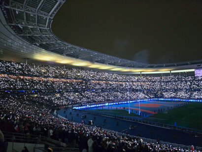 Sous les projecteurs, les Bleus s’apprêtent à affronter l’Écosse tandis que la foule, baignée de lumière, crée une mer d’émotions et de passion dans le Stade