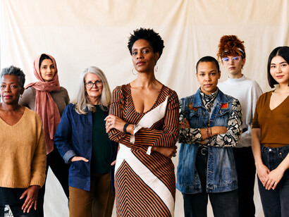 A diverse group of women of various ages share a joyful moment in a portrait highlighting cultural diversity and intergenerational connection