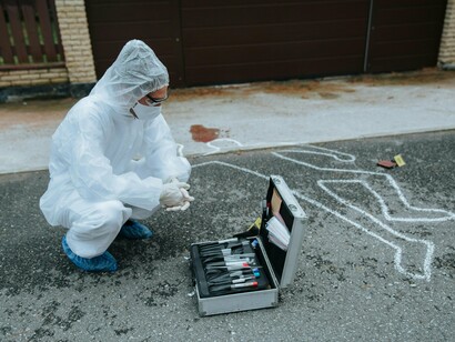 An investigator meticulously documents a crime scene, mirroring the investigative allure that captivates millions of true crime enthusiasts worldwide