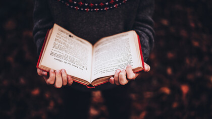 Un hombre se aferra a un libro abierto que contiene muchos misterios