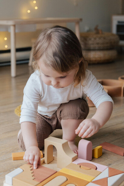 Criança de 3 anos se diverte montando brinquedo educativo, destacando a importância da afetividade no aprendizado infantil