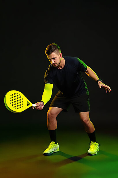 Professional padel player getting ready for a powerful shot in a dynamic indoor court match