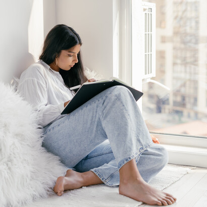 Leitora escreve em seu caderno de anotações