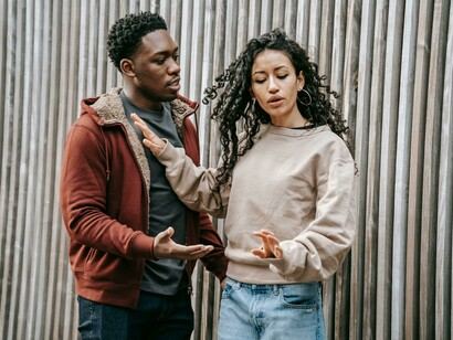 A distressed woman pulls away as her partner grips her hand, conveying emotional strain and control in a toxic relationship