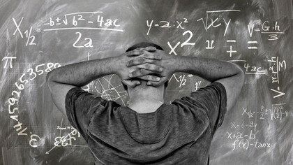 A student staring at the problem on the board at his university, unsure of the answer