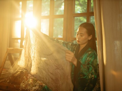 A designer studying the drape and structure of a garment, symbolizing the search for silhouettes that complement the changing female body