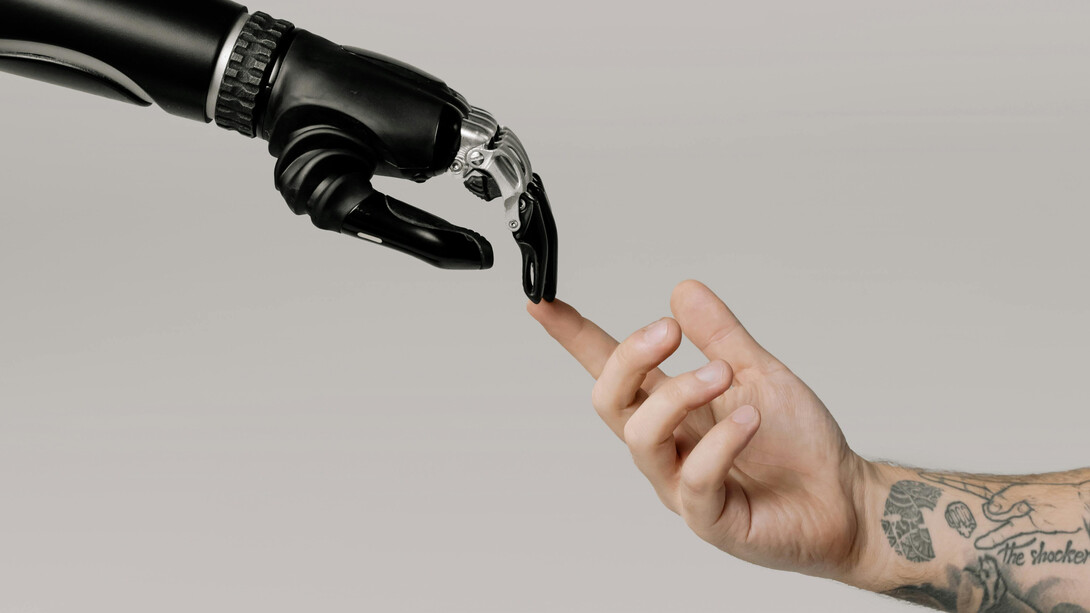 A human and a robotic hand barely touching, alluding to the Renaissance painting "The Creation of Adam", by Michelangelo Buonarroti