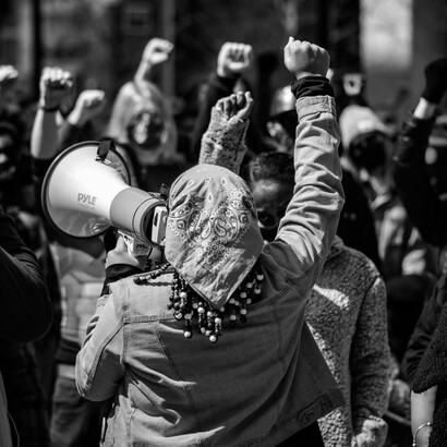 Woman protest by chanting slogans through a megaphone. Psychology serves as the bridge between the abstractions of the mind and the actions of the body and  the material world or what we name “reality” 