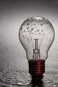 A lightbulb drizzled in water and raising the awareness to the question of whether or not water can store energy