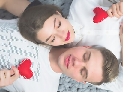 A romantic duo lounging amid miniature heart symbols, epitomizing affection and intimacy