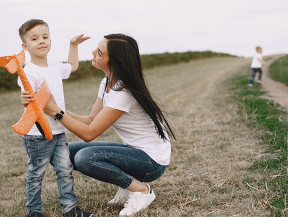 A mother and her young son playing with a toy plane, highlighting self-expression, autonomy, and the parent-child relationship