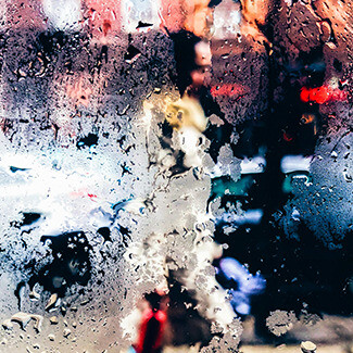 Pessoa caminhando na chuva. O helicóptero, com um forte projector apontado para o passeio, manteve-se fixo no ar por alguns segundos e também ele seguiu os outros