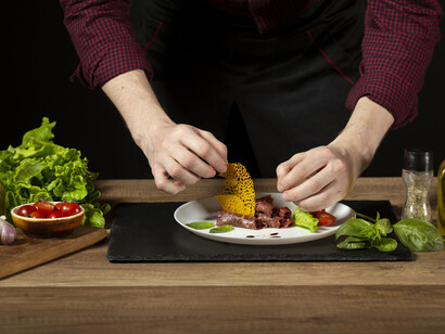 A person working with colourful produce, highlighting the connection between national policies and household meals