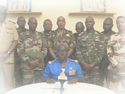 Col. Major Amadou Abdramane, center, with soldiers, is shown speaking during a televised statement, claiming on July 26, 2023, to have overthrown the government of Niger President Mohamed Bazoum