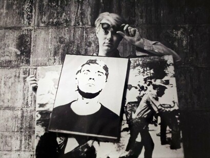 Andy Warhol with “Self Portrait” and “Birmingham Race Riot” Homemade Sandwich Boards Standing In Front Of Wall At The Factory (detail). Image copyright William John Kennedy. Courtesy of Woodbury House 
