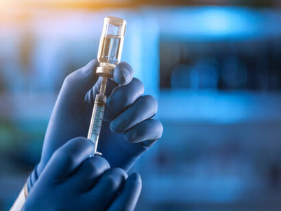 An illustrated medical hand in a glove grips an ampoule containing a vaccine and a syringe, emphasizing the vital process of immunization in preventing infectious diseases