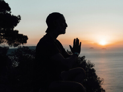 Silueta de un hombre meditando cerca del mar