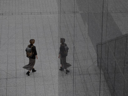 A solitary figure walking amidst towering urban skyscrapers, embodying themes of alienation and individuality