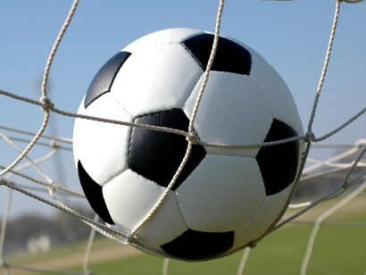 A football inside a goal net