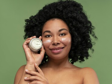 A woman holding a jar of facial cream, reflecting the benefits of barrier-supportive skincare