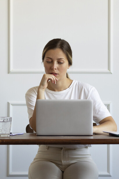 Exhausted from desk job fatigue, a woman stretches at her workstation in an attempt to relieve tension