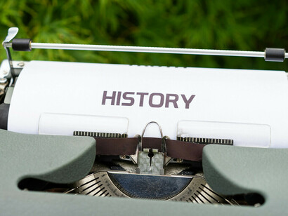 Una máquina de escribir con una hoja en la que se lee la palabra historia