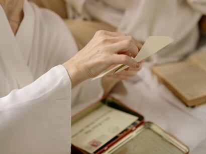 A person carefully unfolding a handwritten letter, representing the rediscovery of treasured memories and emotions