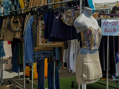 Close-up of secondhand clothes hanging neatly on a rack at a flea market, capturing the essence of sustainable fashion in everyday spaces