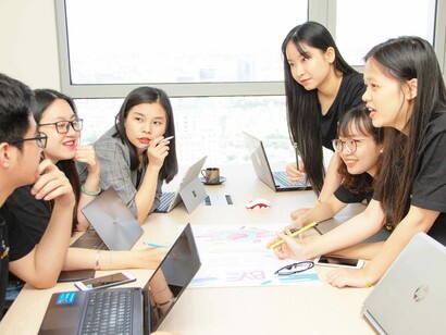 In an office setting, coworkers are working as a team and searching for input to get the task accomplished in a smooth and friendly manner