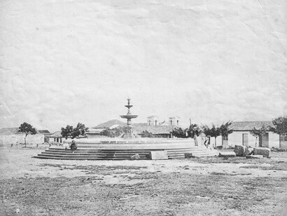 Plaza Mayor de Cartago, hacia el año 1874. Se observa la desaparecida Fuente de los Leones en primer plano, y al fondo, a la izquierda, las tapias del cementerio de la Parroquia, y a la derecha, las torres del convento franciscano. Foto de autor desconocido, propiedad del Archivo Nacional de Costa Rica