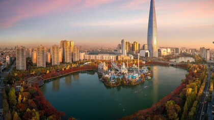 During autumn in Seoul, South Korea, the vibrant colors of the leaves surround the peaceful lake in the park