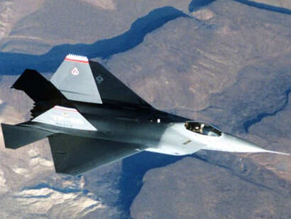 An air-to-air overhead view captures the Lockheed YF-22 advanced tactical fighter aircraft during a test flight, showcasing cutting-edge stealth and low-observable technology