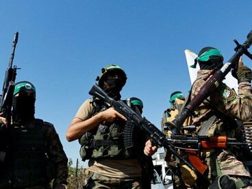 Combatentes do Hamas participam de uma manifestação portando armas e símbolos associados ao movimento palestino. A presença do grupo evidencia uma das principais frentes do chamado “Eixo de Resistência”, rede de organizações aliadas ou próximas ao Irã que amplia a dimensão regional do conflito entre Israel e seus adversários