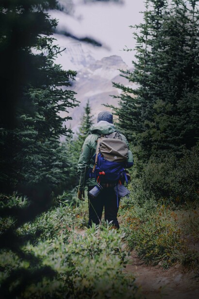 Un joven recorriendo un sendero en el bosque, a mitad del camino