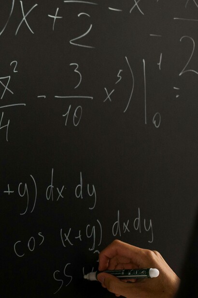Numeri e simboli matematici su una lavagna: "... la realtà è così complessa da sfidare qualsiasi spiegazione semplicistica, soprattutto quella del materialismo puro"