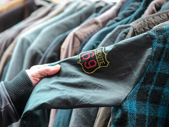 A shopper browsing through a rack of second-hand shirts at a charity shop, embracing sustainable fashion choices