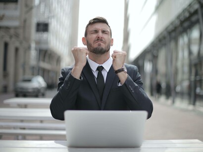 A man celebrating his success after an online transaction