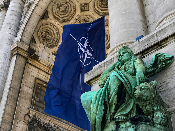 NATO flag displayed beneath the historic arcades of the Cinquantenaire in Brussels, Belgium