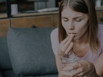 Practical methods of managing food sensitivities while witnessing a young woman effortlessly take medication with a glass of water, seamlessly incorporating dietary restrictions into her lifestyle