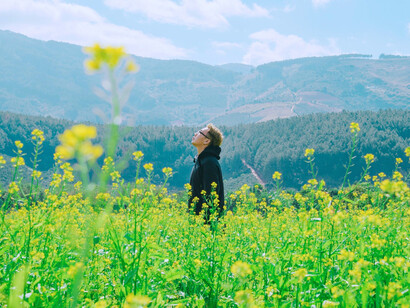 A person standing quietly in a field, reflecting the importance of reconnecting with the physical world