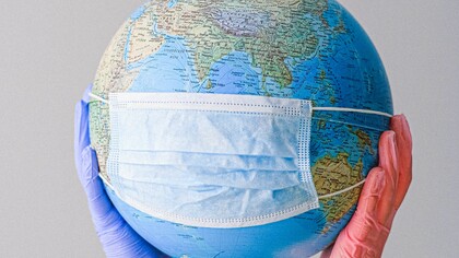 Um globo do planeta terra com máscara contra o Covid 19