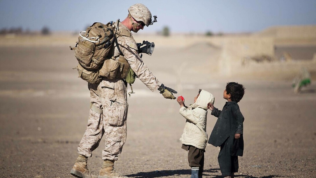 Soldier giving candy to children